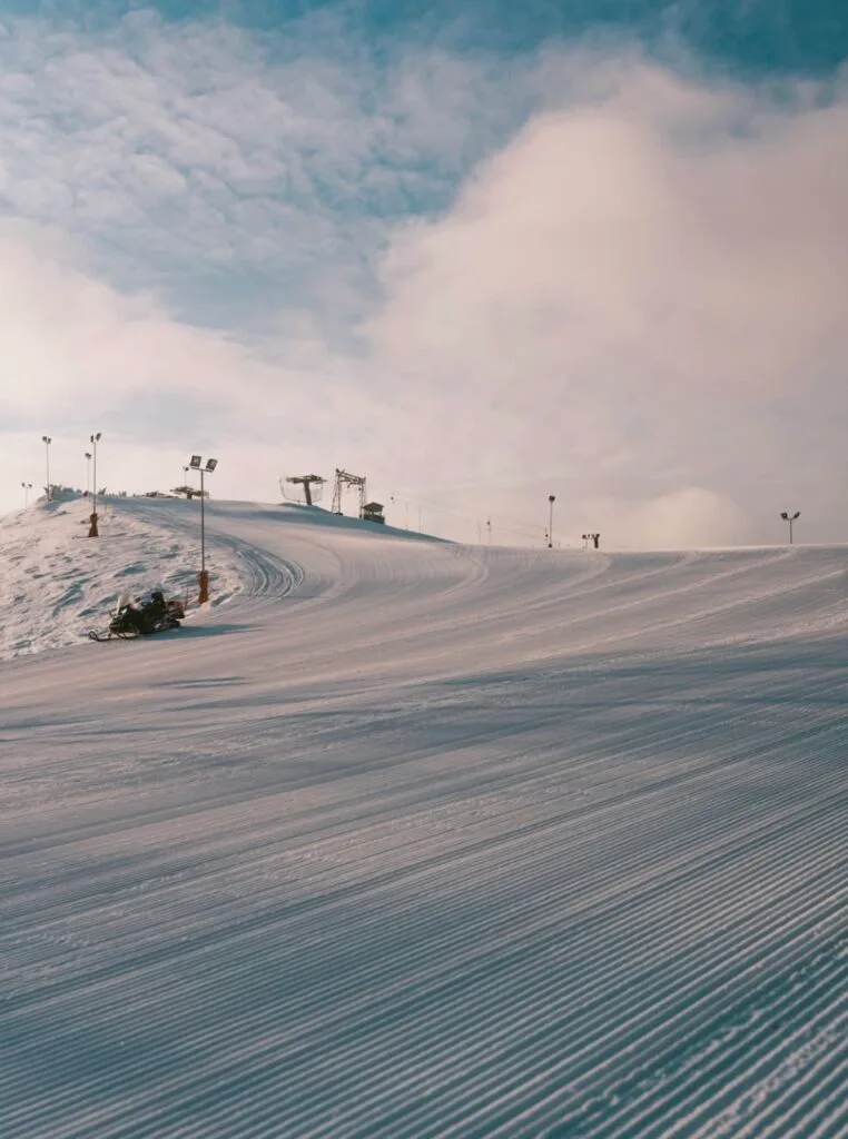 Brightly illuminated slope at Liepkalnis with a man skiing down the hill.