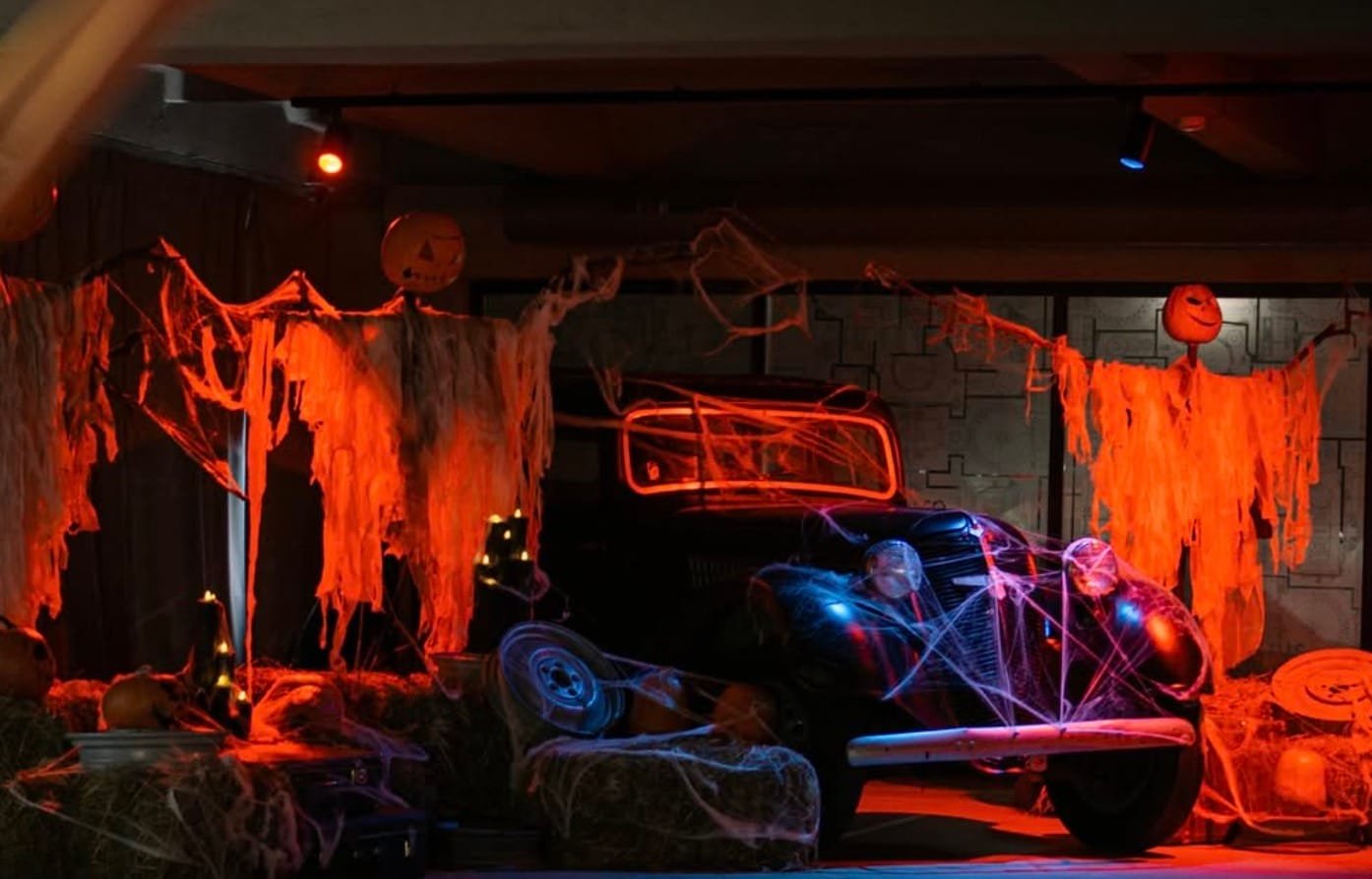 Vintage car decorated with cobwebs and Halloween figures at the Auto Museum.