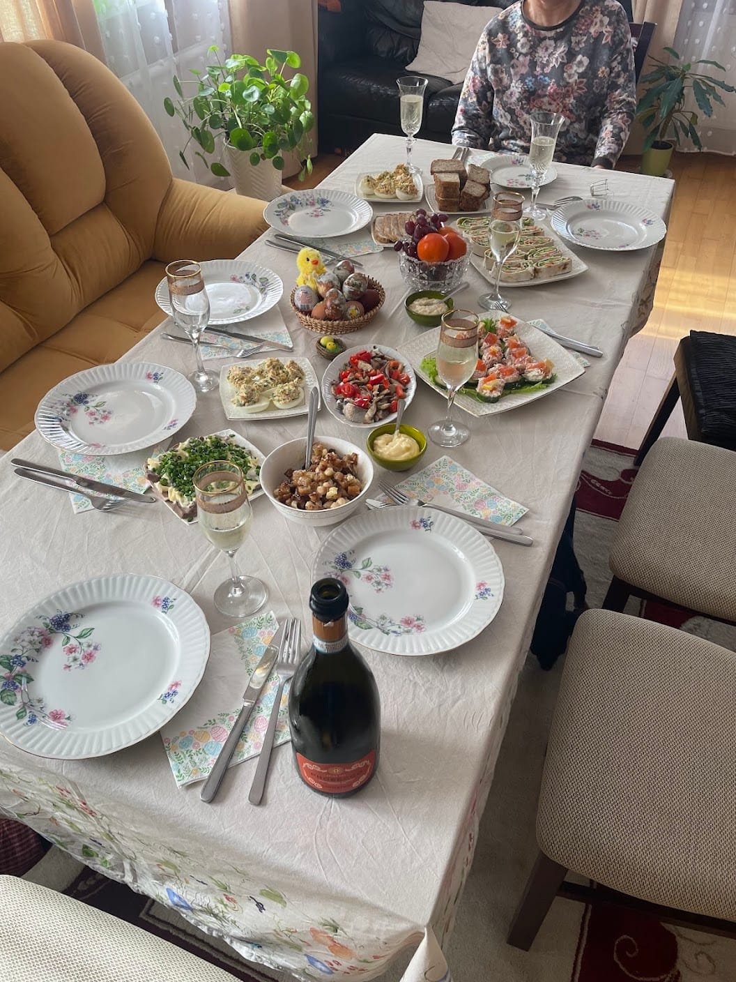Festive Easter table filled with traditional dishes, colored eggs, and drinks.