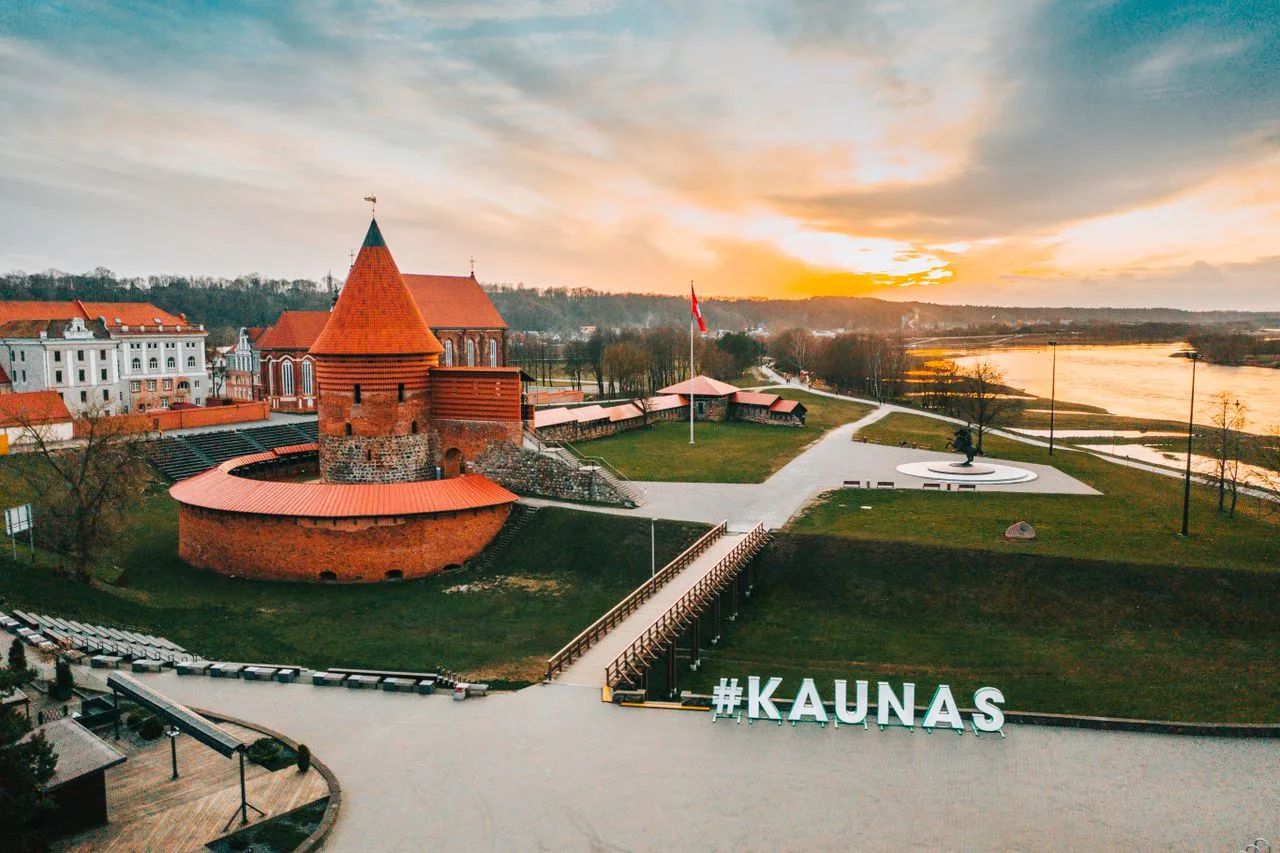 Aerial view of Kaunas castle near the river at sunset with a Kaunas city landmark sign