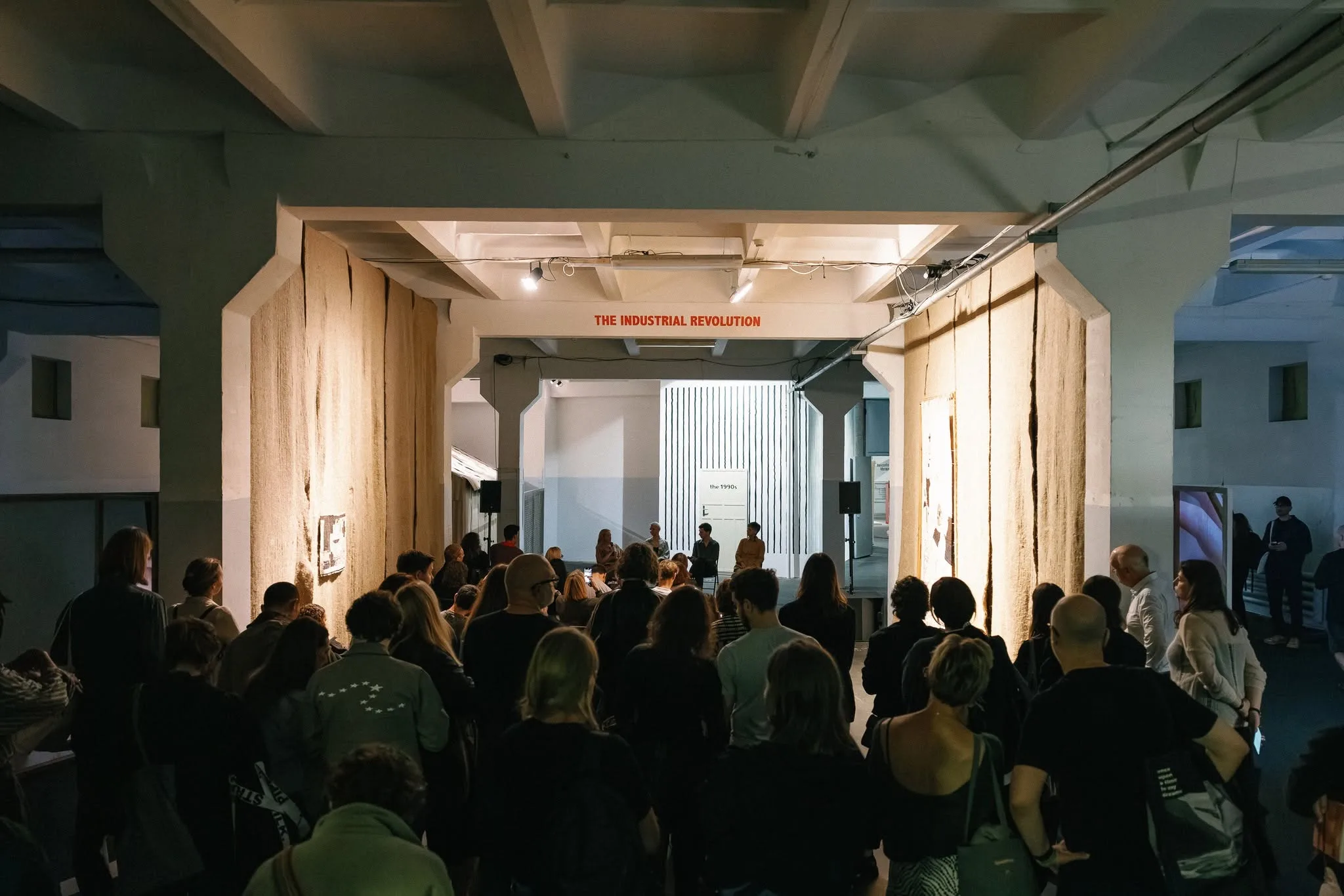 Visitors attending a contemporary art exhibition inside an industrial hall at Kaunas Biennial