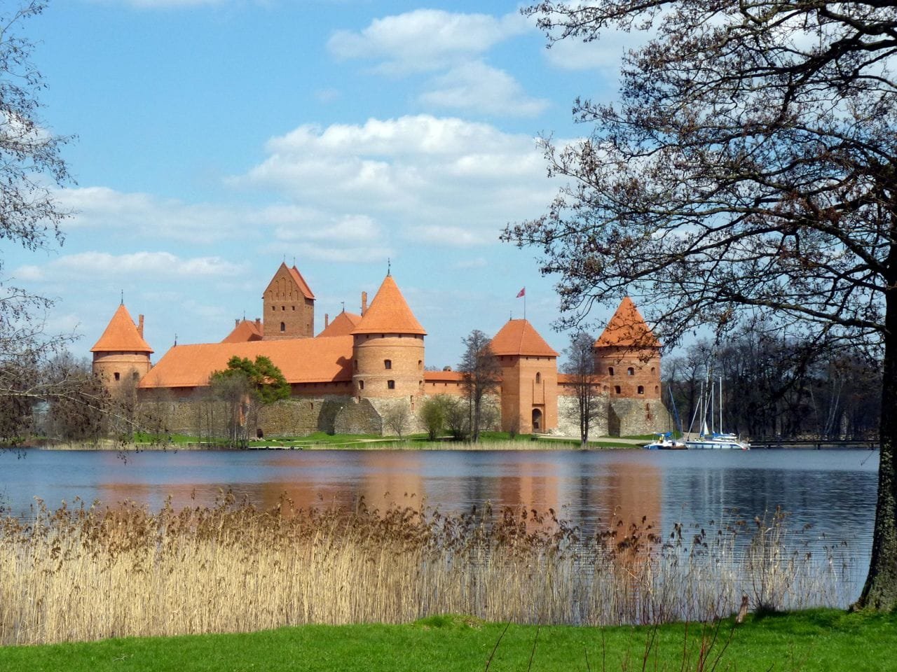 Red brick Trakai Island Castle reflected in the calm lake water.