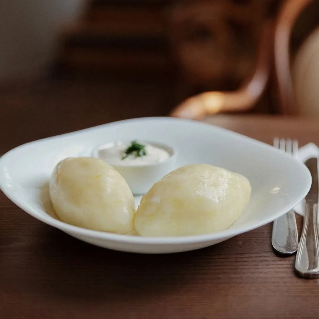Traditional Lithuanian potato dumplings cepelinai served with sour cream at Valerijonas tea room.