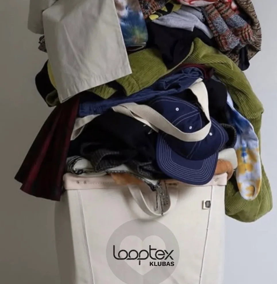 A large pile of trendy pre-owned clothes and caps in a "Looptex" club bin.