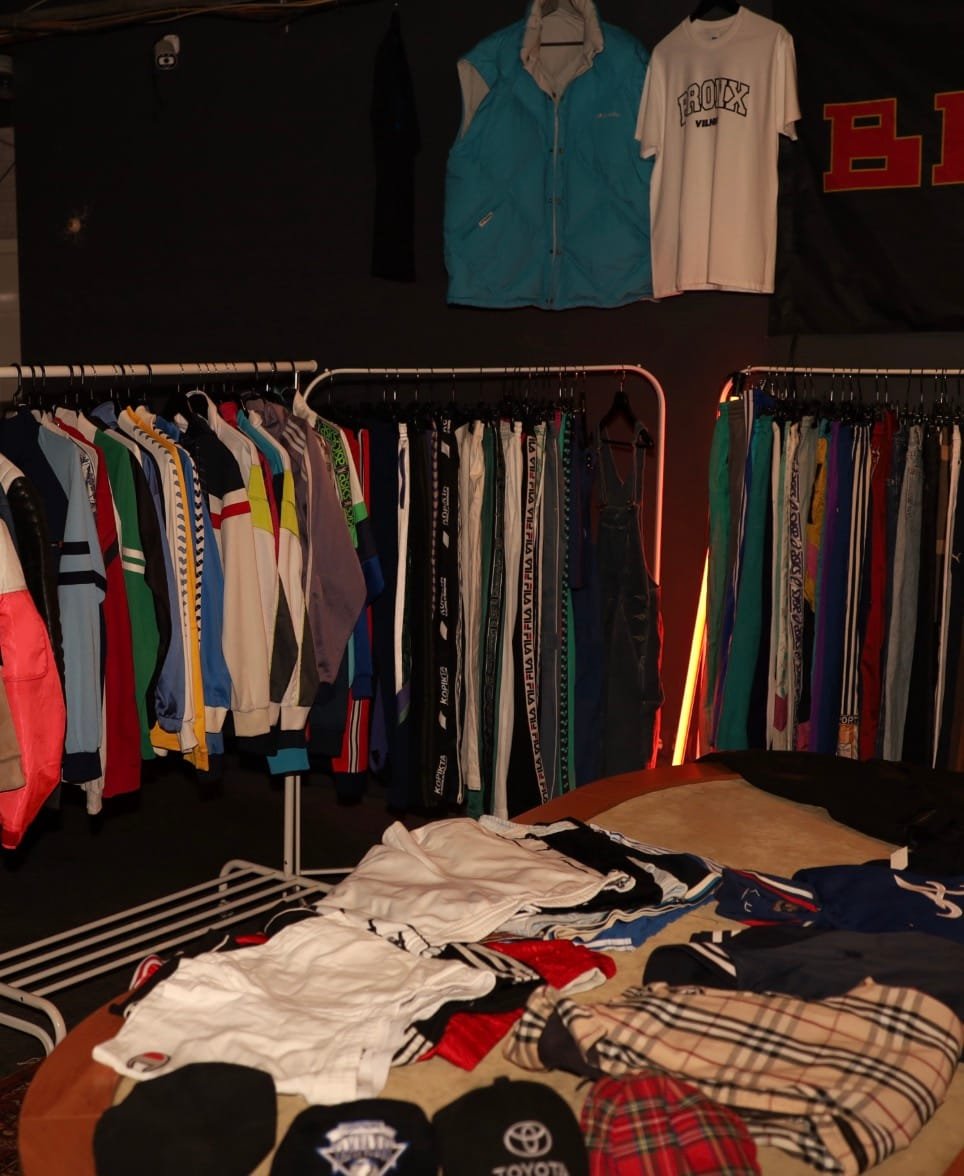 Selection of vintage sportswear and streetwear on racks and a table.