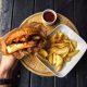 Juicy burger with crispy fries served on a wooden platter, a top pick from our best burgers in Vilnius guide.