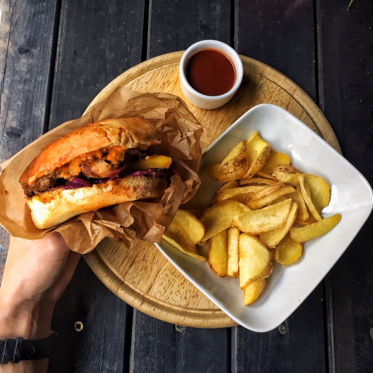 Juicy burger with crispy fries served on a wooden platter, a top pick from our best burgers in Vilnius guide.