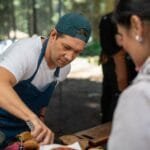 Chef serving food at an outdoor event during Food and Drink Festivals in Lithuania.
