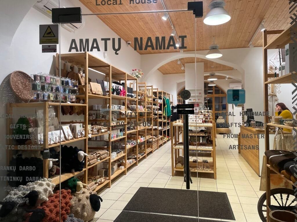 People shopping in Kaunas on Laisvės Alėja, surrounded by boutiques and café terraces in the Old Town.
