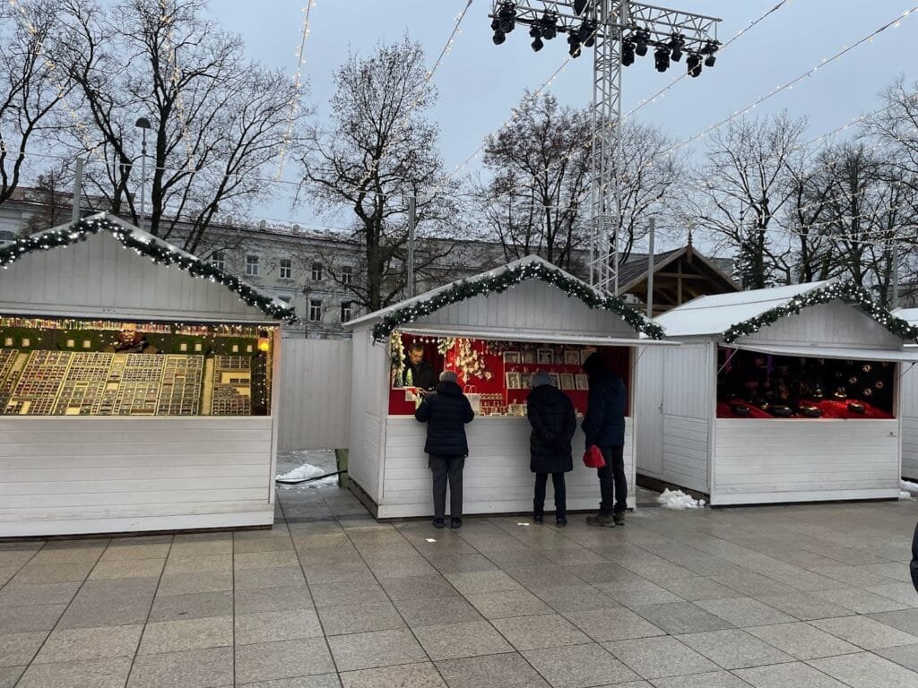 What to do in Vilnius at Christmas: festive market with lights and wooden holiday stalls.