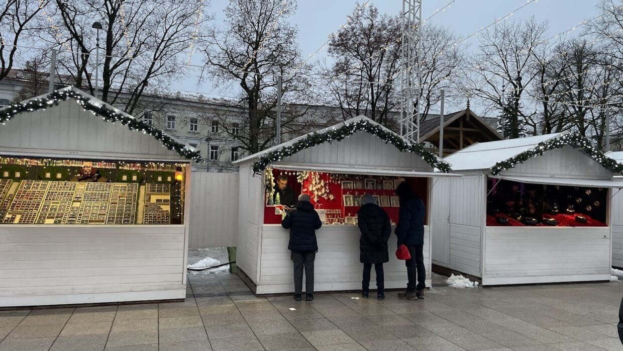 What to do in Vilnius at Christmas: festive market with lights and wooden holiday stalls.