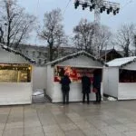 What to do in Vilnius at Christmas: festive market with lights and wooden holiday stalls.