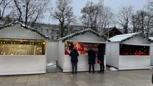 What to do in Vilnius at Christmas: festive market with lights and wooden holiday stalls.