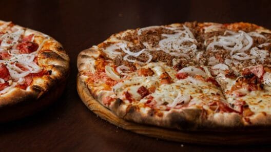 Two baked pizzas served on wooden boards for a guide on the best pizza in Kaunas.