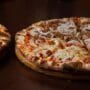 Two baked pizzas served on wooden boards for a guide on the best pizza in Kaunas.
