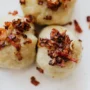 Traditional potato dumplings topped with bacon – a dish for Lithuania for foodies guide.