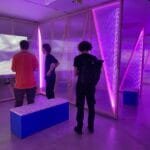 Visitors exploring interactive video installations in a modern museum - museums for kids in Vilnius.