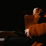 Person sitting in a cinema theater holding popcorn - Lithuanian movies in 2026.