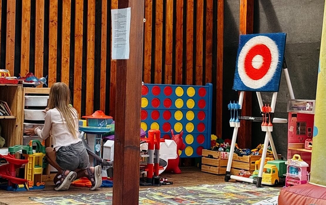 Girl playing in a designated kids' play area with toys and games - family friendly restaurants in Kaunas.