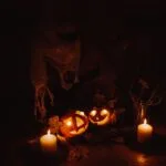 Carved glowing jack-o'-lantern pumpkins and candles illuminated in the dark - pumpkin events in Lithuania.