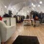 Bright and spacious interior of vintage clothing stores in Vilnius with racks and shoppers.